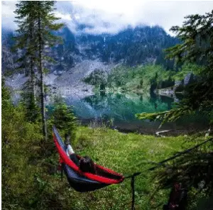 hammock camper looking at lake mountains