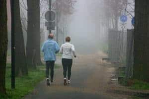 two joggers running foggy morning