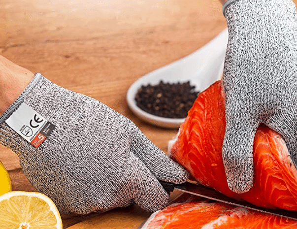 gloved hands cutting salmon fillet