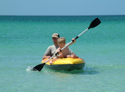 father and son kayaking on beach